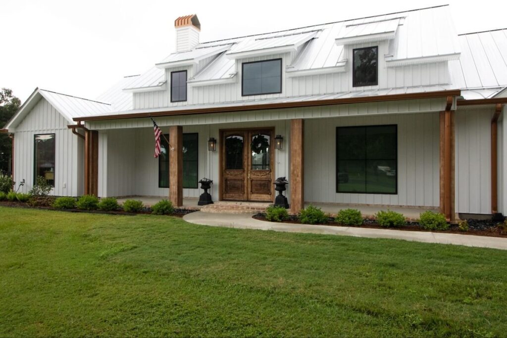 Modern farmhouse with white TruLog steel siding, black window trim, and a white metal roof.