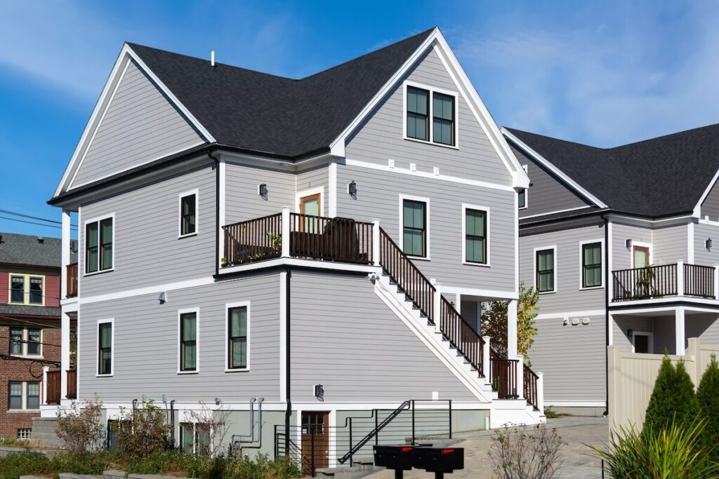A two-story home with a cross-gable roof and light gray lap siding