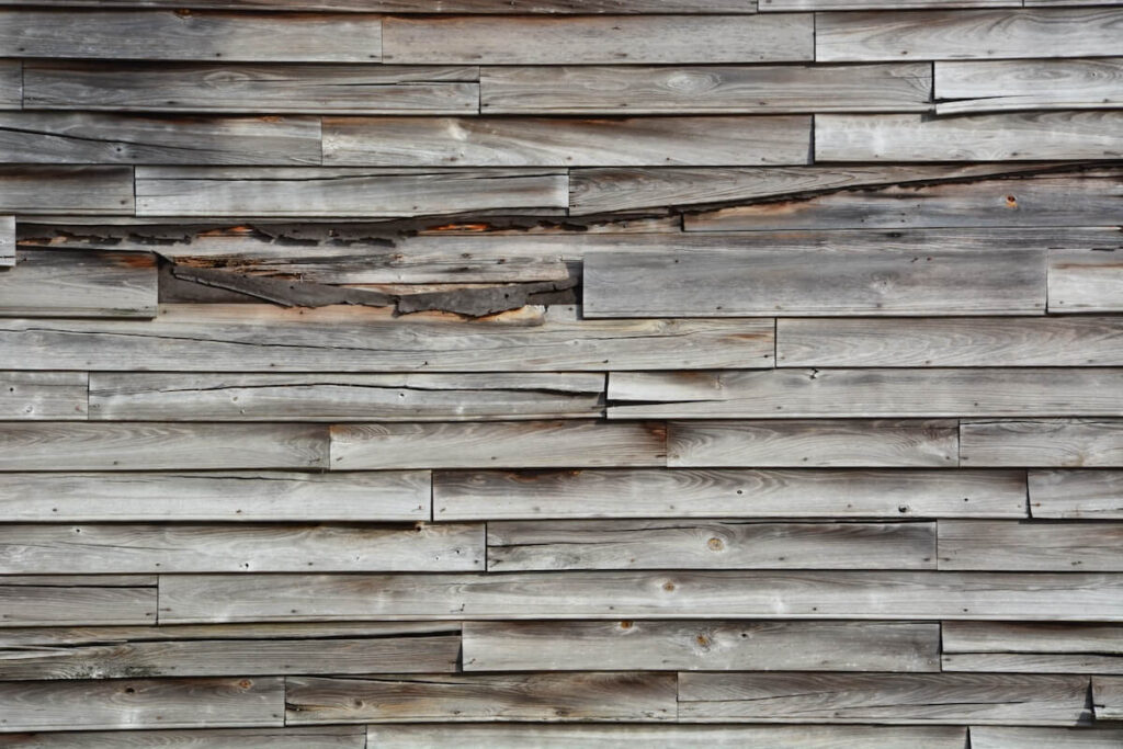 A closeup of rotting wood siding