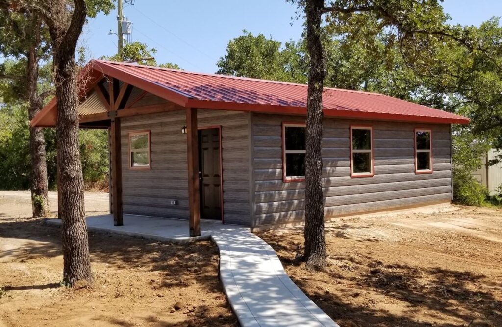 A small manufactured home with TruLog steel log siding and a metal roof