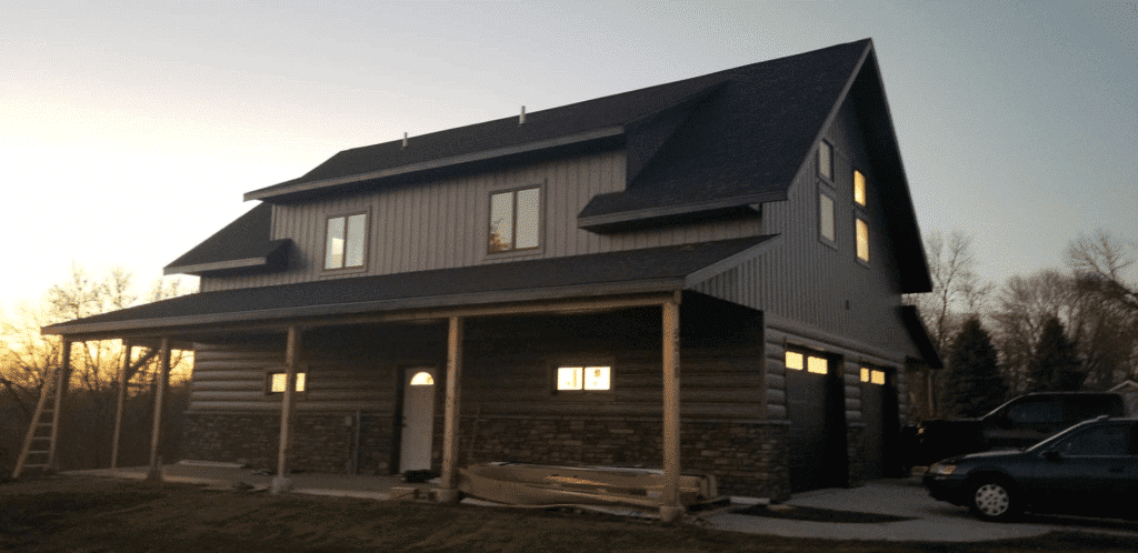 A bardominium during sunrise with a combination of TruLog steel log siding and board and batten siding