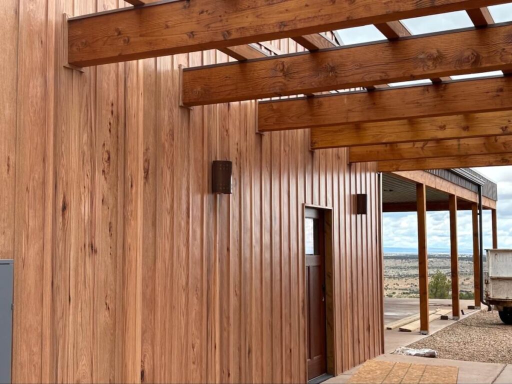 A home with TruLog steel board and batten siding in the color Hickory