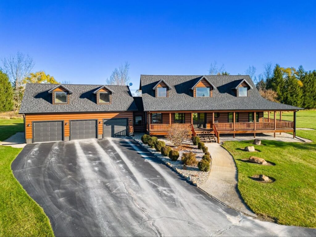 A large cabin and three-car garage with TruLog steel log siding