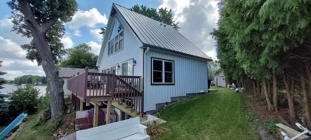 A waterfront cottage featuring TruLog steel board and batten siding