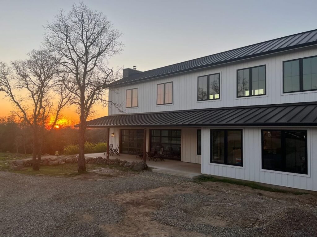 A home during sunset with a vinyl siding alternative, TruLog's steel board and batten siding in matte white