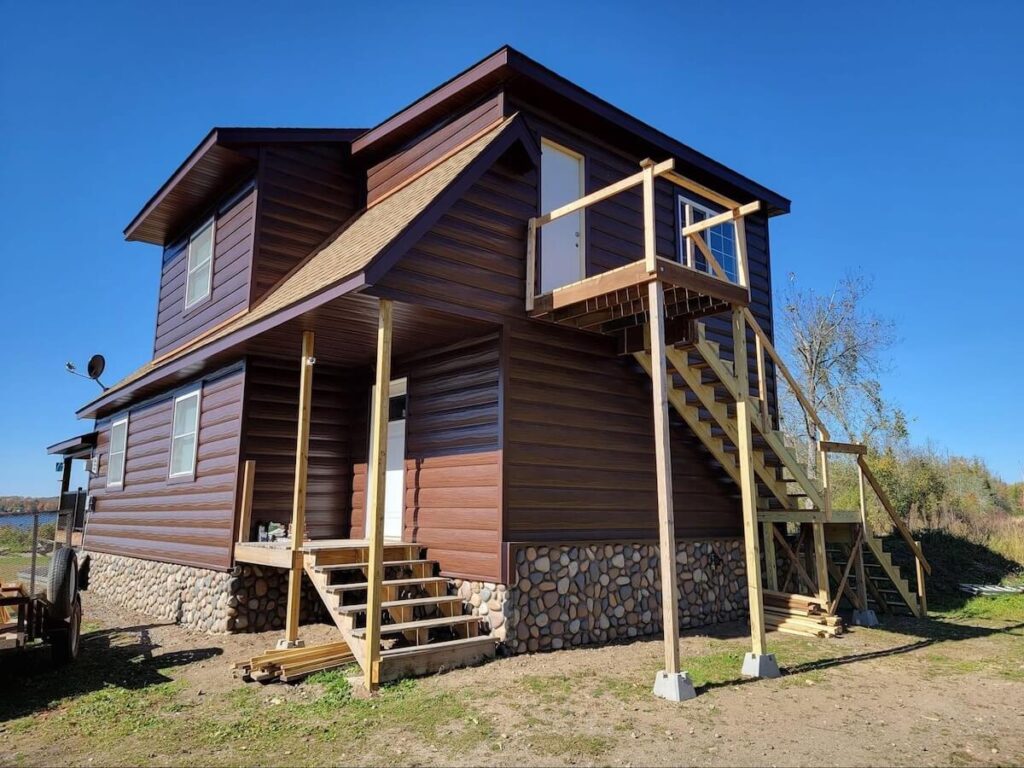 A home with a combo of two of the best sidings for houses: stone veneer and TruLog steel log siding