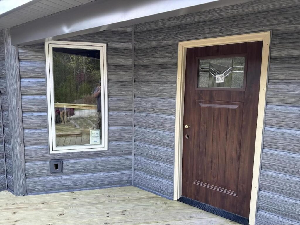 A closeup of a home with TruLog steel log siding in weathered gray