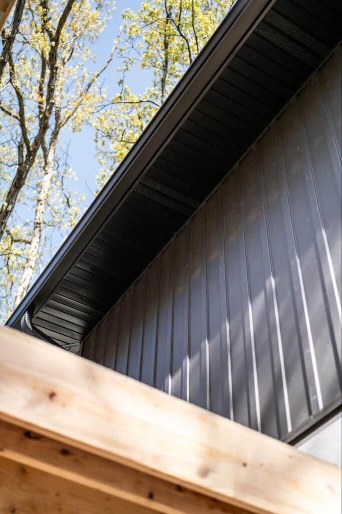 The closeup of a home's TruLog steel board and batten siding with matching roof soffit