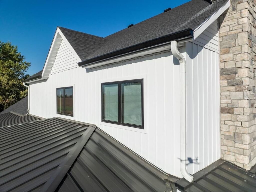 A closeup of the upper level of a home with a mix of TruLog board and batten and lap siding in matte white