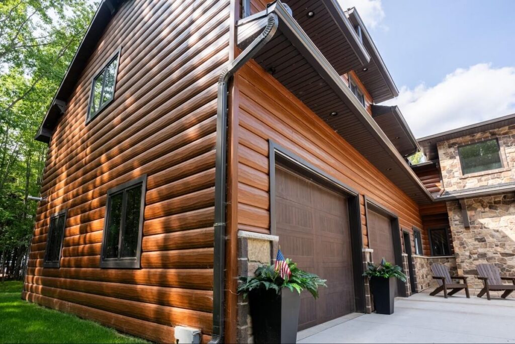 A closeup of the garage and side of a home with low-maintenance TruLog steel log siding