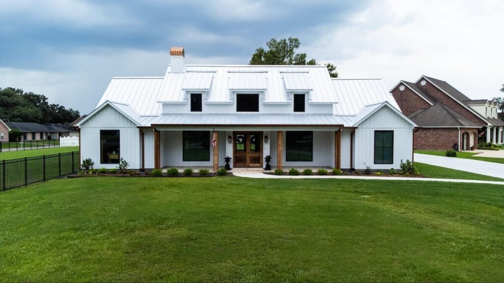 A modern farmhouse with a white metal roof, wood accents, and TruLog steel board and batten siding