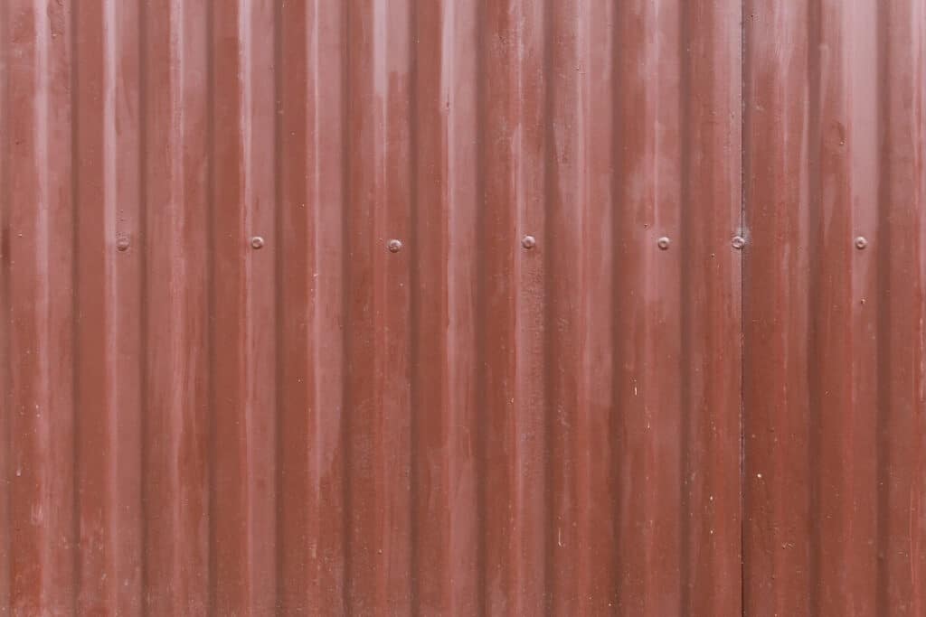 Red aluminum siding with a chalky look from exposure to the elements, one of the disadvantages of this siding material