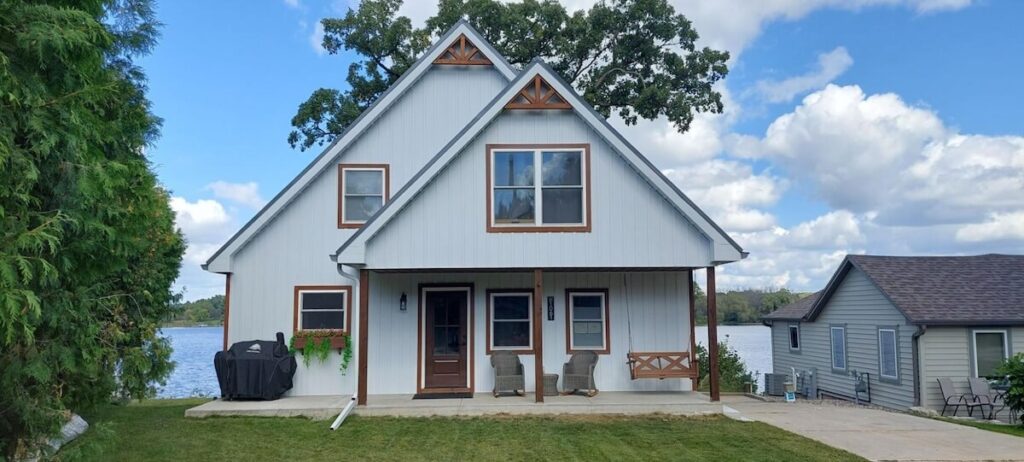 A lakeside cottage with impact-resistant TruLog steel board and batten siding