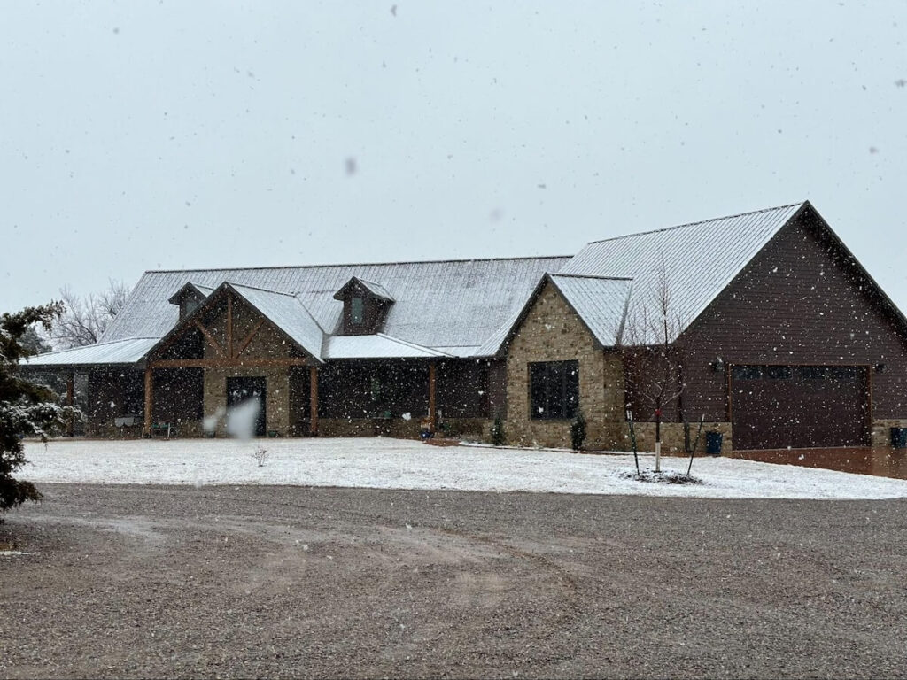 Snow falling on a beautiful home with TruLog steel siding