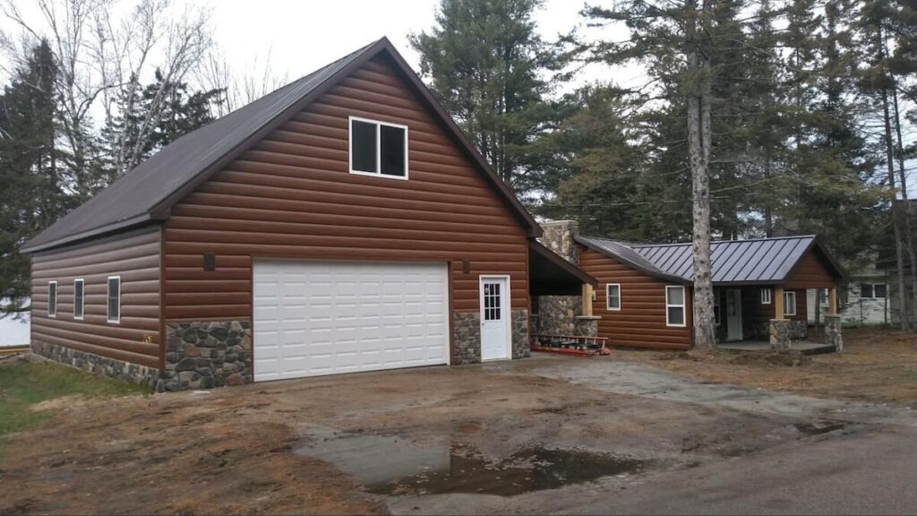 Log-themed house with a large garage