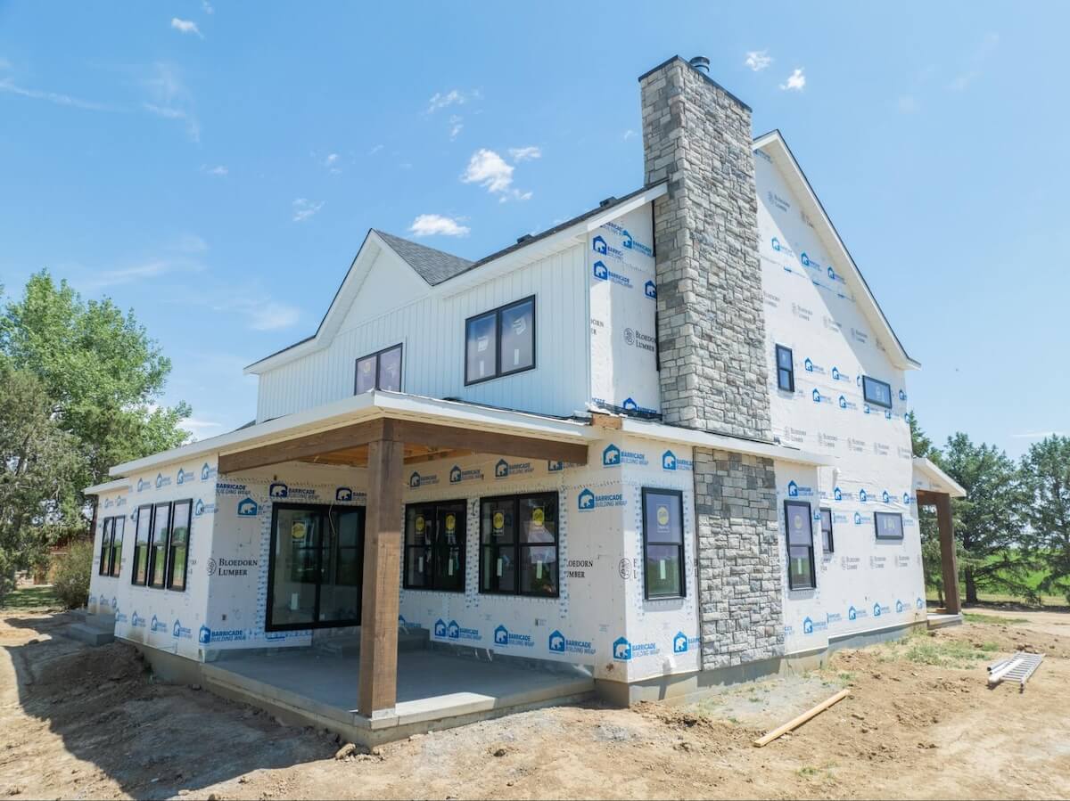 The exterior of a home with house wrap having TruLog steel board and batten siding installed