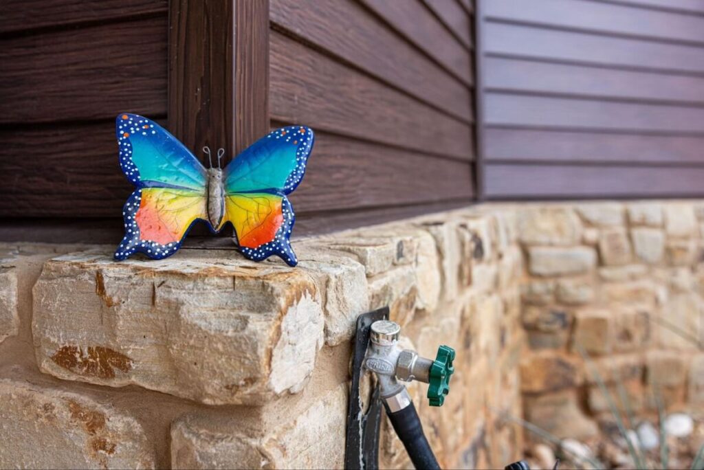 A closeup of a home with a stone foundation and TruLog steel lap siding