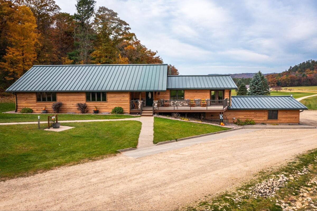 An updated ranch with a green metal roof and TruLog steel log siding in Hickory