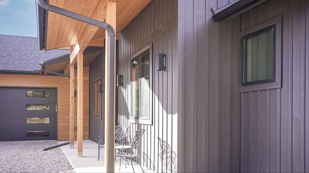A close up of a home's front exterior with TruLog steel siding and wood accents