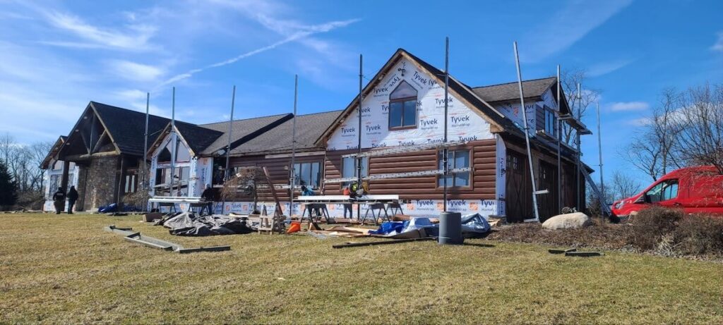 A crew installs new TruLog steel log siding on a home