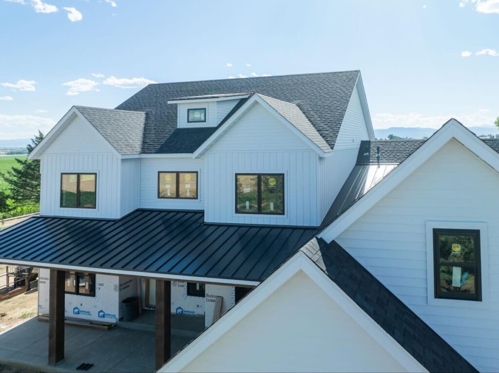 TruLog steel siding on a modern farmhouse-style home with white board and batten exterior and black metal roof.