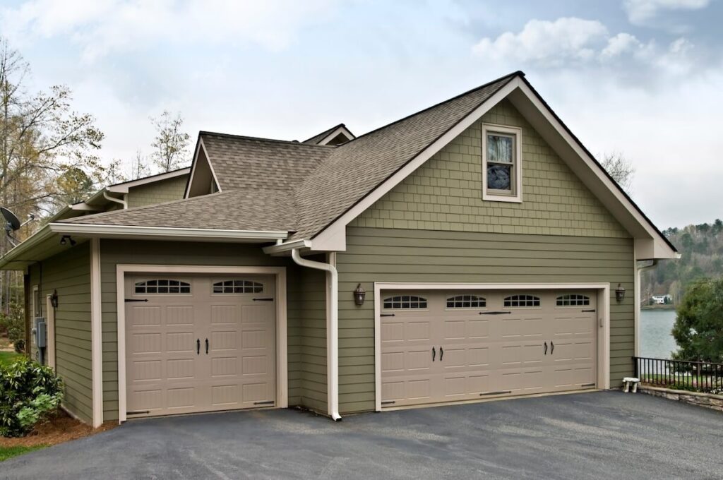 A modern home with green fiber cement lap siding and shake-style gables against a cloudy sky.
