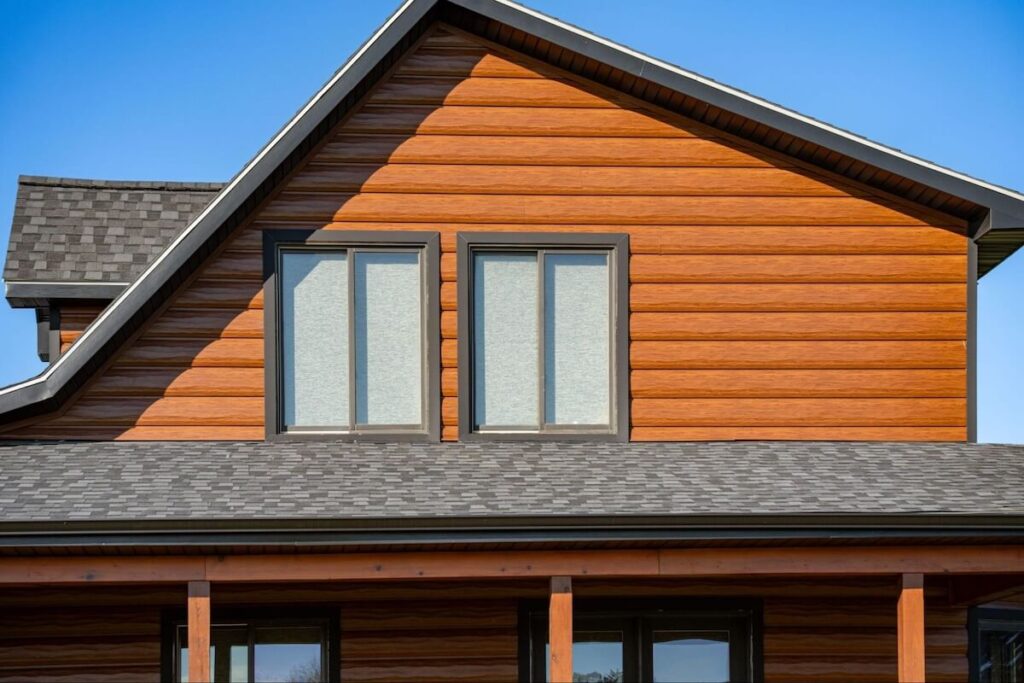 Close-up of a home's gable and roofline featuring warm-toned TruLog siding with soffitting visible beneath the eaves.